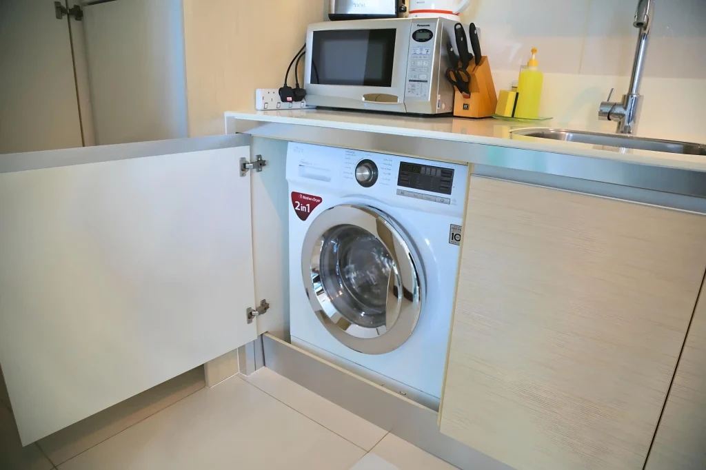 Washing machine and microwave in laundry room.