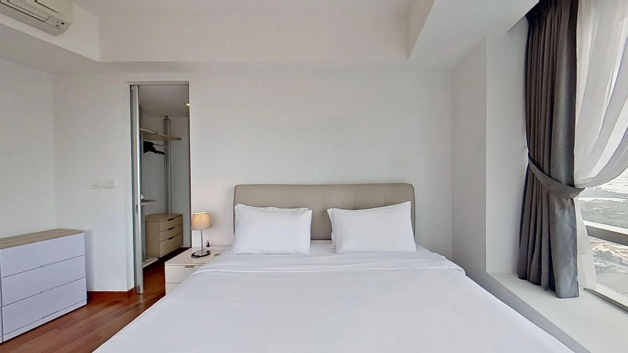 Bedroom with bed, chest of drawers, throw pillows.
