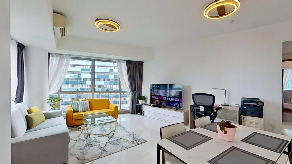 Modern living room with couch, chair, table, and light fixture.