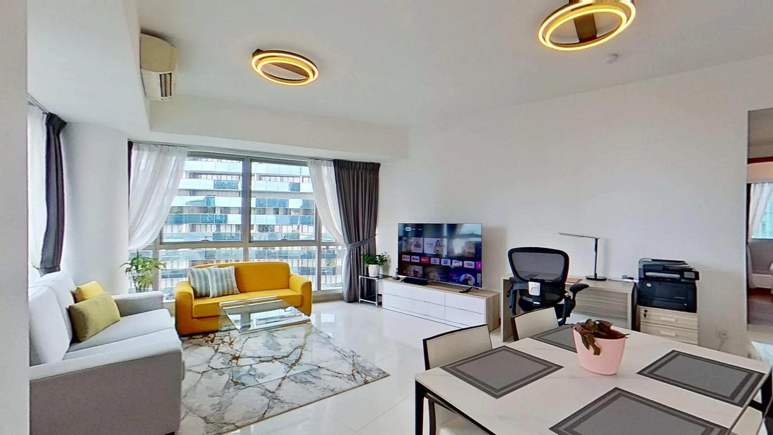 Modern living room with couch, chair, table, and light fixture.