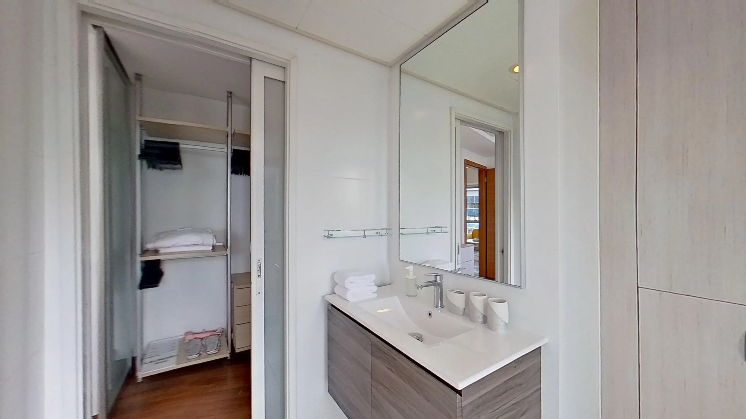 Modern bathroom with wood flooring, sink, and cabinet.