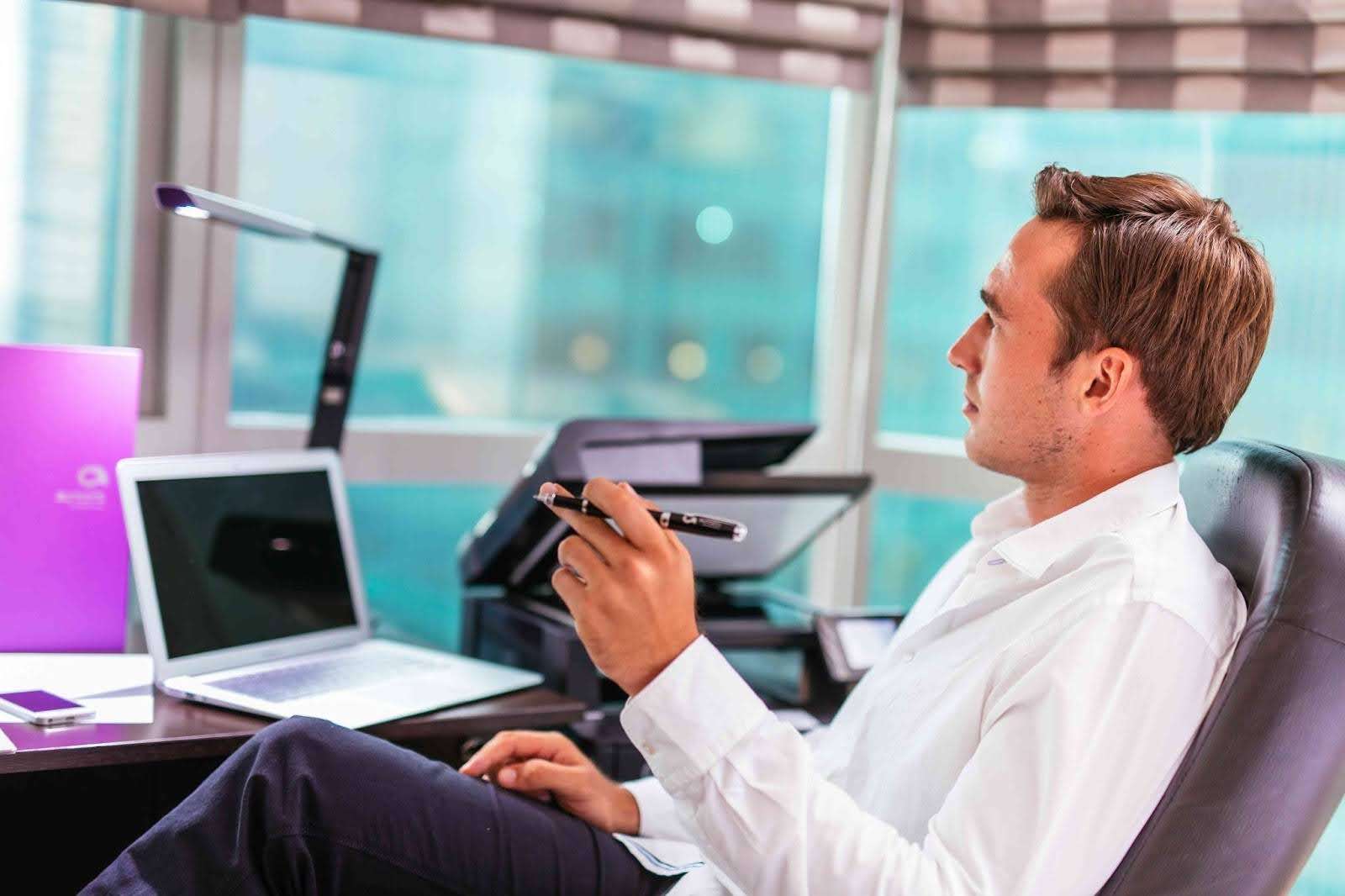 Business traveller working at a desk in a luxury serviced apartment workspace