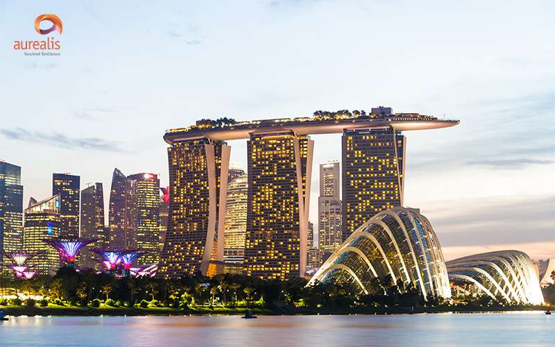 Twilight view of Marina Bay Sands and Gardens by the Bay, with city lights and iconic arch