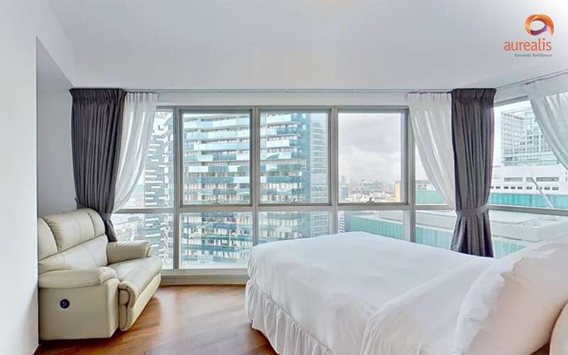 Modern bedroom with large windows and city view.