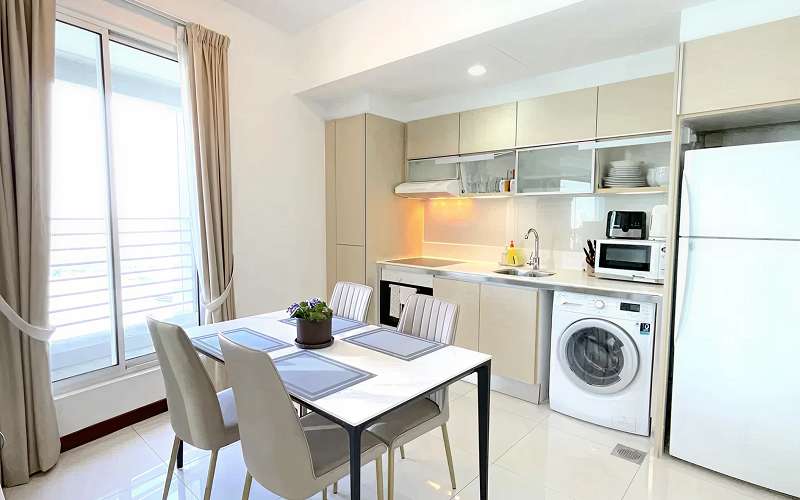 Aurealis serviced apartment kitchen featuring fully equipped cooking facilities and in-unit laundry amenities.