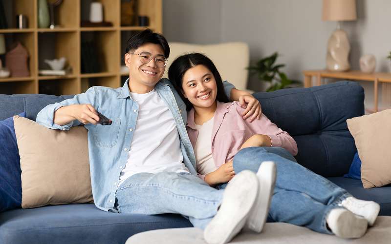 Happy couple relaxing in a Singapore 2-bedroom serviced apartment.